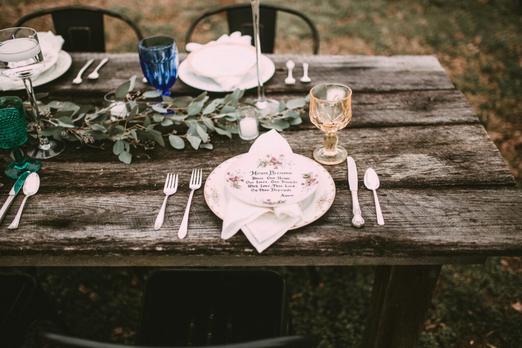 Charming rustic wedding table setting with vintage tableware and greenery.